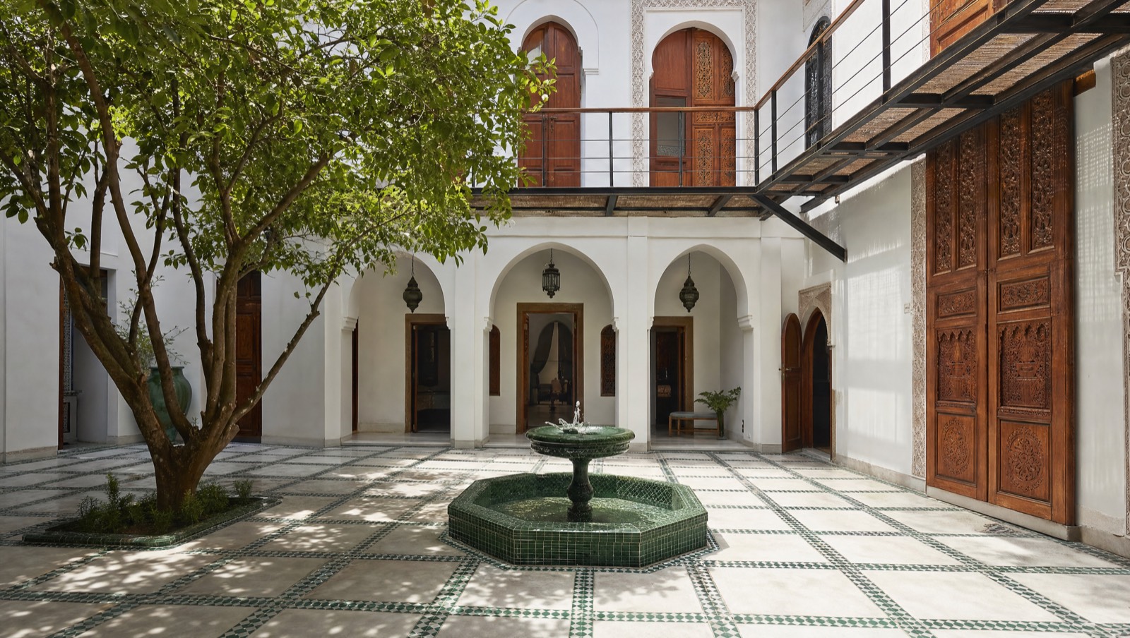 Patio de riad réhabilité à Rabat, arcades blanches, fontaine en zellige et passerelle en acier